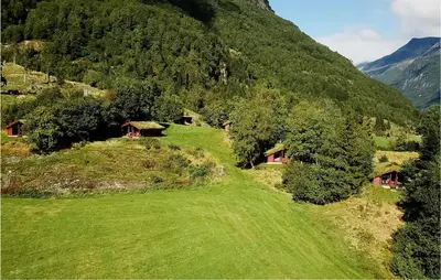 a green field with houses on a mountain at Flåten Hyttegrend in Olden