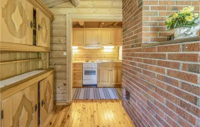 a kitchen with wooden cabinets and a brick wall at Beautiful Home In Olden With Sauna in Olden
