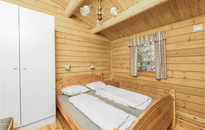 a bed in a log cabin with a window at Beautiful Home In Olden With Sauna in Olden