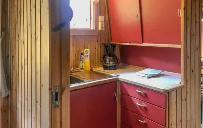 a small kitchen with red cabinets and a sink at Holiday Home Olden Gjerde in Olden