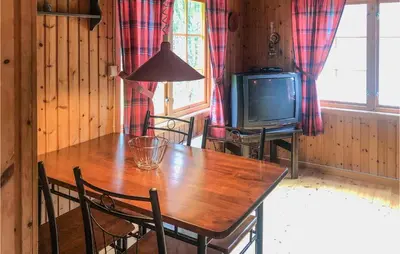 a dining room with a wooden table and a television at Holiday Home Olden Gjerde in Olden