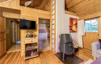 a living room with a flat screen tv in a log cabin at 3 Bedroom Amazing Home In Sandane in Sandane