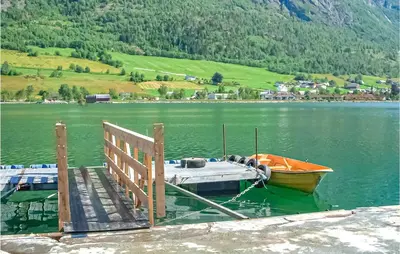 a boat is docked at a dock on a lake at Amazing Home In Olden With Wifi in Olden
