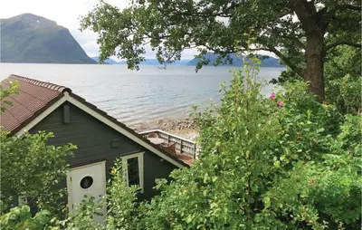a house on the shore of a body of water at Beautiful Home In Hundeidvik in Hundeidvik