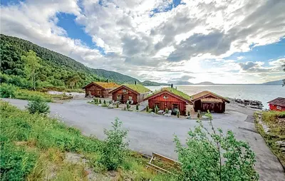 a group of cabins on the shore of a lake at Hytte 19 in Ikornnes