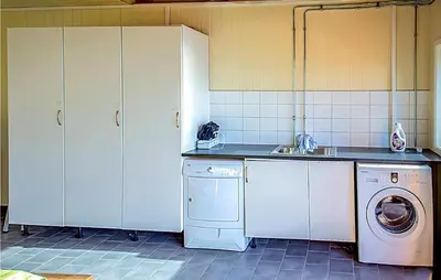 a kitchen with a washing machine and a sink at Hytte 19 in Ikornnes