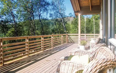a porch with wicker chairs and a fence at Stunning Home In Stranda With Sauna in Stranda