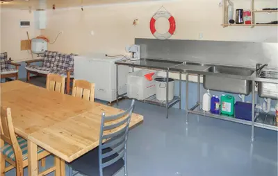 a kitchen with a table and a table and chairs at 4 Bedroom Beautiful Home In Hundeidvik in Hundeidvik