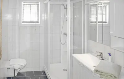 a white bathroom with a shower and a sink at 4 Bedroom Beautiful Home In Hundeidvik in Hundeidvik