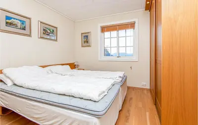 a bed in a room with a window at Gorgeous Home In Hundeidvik in Hundeidvik