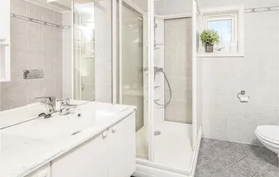 a white bathroom with a sink and a shower at Gorgeous Home In Hundeidvik in Hundeidvik