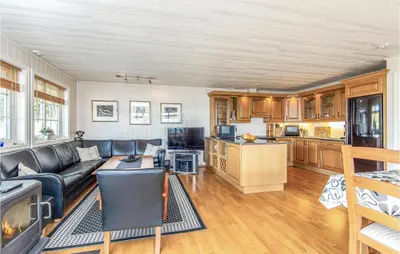 a living room with a couch and a kitchen at Gorgeous Home In Hundeidvik in Hundeidvik