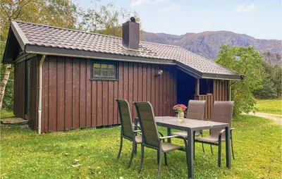a table and chairs in front of a cabin at Holiday Home Isfjorden Isfjorden in Isfjorden