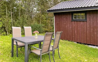a table and chairs with a table and a shed at Holiday Home Isfjorden Isfjorden in Isfjorden