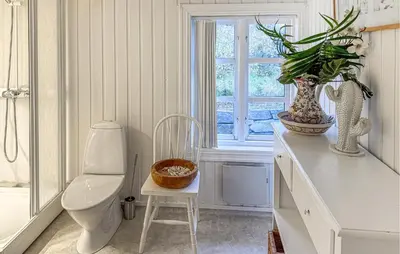a bathroom with a toilet and a window and a chair at Evastua in Averoy