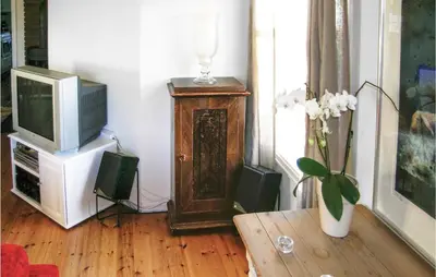 a living room with a television and a vase of flowers at Evastua in Averoy