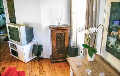 a living room with a television and a vase of flowers at Evastua in Averoy