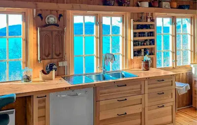 a kitchen with a sink and some windows at Idavolden in Stangvik