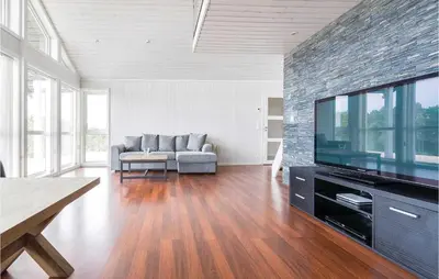 a living room with a couch and a flat screen tv at 4 Bedroom Lovely Home In Kvisvik in Kvisvik
