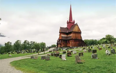 a church in a field with gravestones in front at Amazing Home In Ringebu in Ringebu
