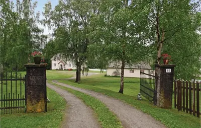 a driveway with a gate with two pillars with flowers on them at Amazing Home In Ringebu in Ringebu