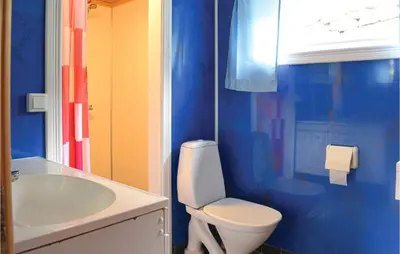a blue bathroom with a toilet and a sink at Holiday Home Heidal Bakketun in Heidal
