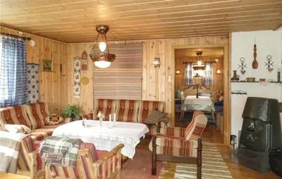 a living room with a table and a bedroom at Kveldsro in Eina