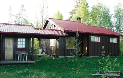 a small cabin with a red roof in a yard at Kveldsro in Eina