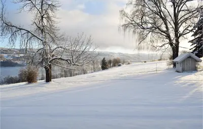 a snow covered road with a small shed on the side of a hill at 3 Bedroom Amazing Home In Vestsida in Fall