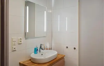 a white bathroom with a sink and a mirror at 3 Bedroom Amazing Home In Vestsida in Fall