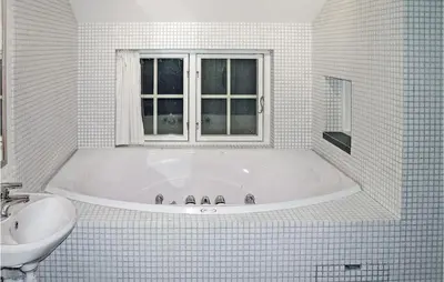 a white bathroom with a tub and a sink at Holiday Home Gålå Peer Gyntlia Iv in Gålå
