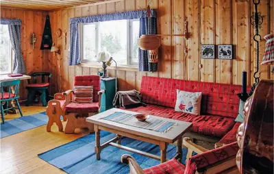 a living room with a red couch and a table at Trollbu Granåsenfefor in Vinstra
