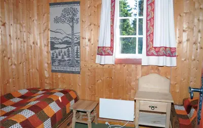 a bedroom with a bed and a window and a table at Trollbu Granåsenfefor in Vinstra
