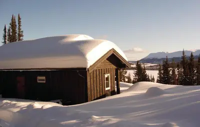 a small building with a snow covered roof in the snow at Trollbu Granåsenfefor in Vinstra