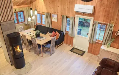 a living room with a table and a couch and a fireplace at Holiday Home Sjusjøen Tyrily in Sjusjøen