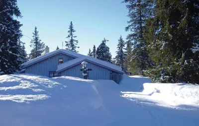 a house with a pile of snow in front of it at Holiday Home Sjusjøen Tyrily in Sjusjøen