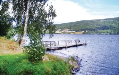a dock in the middle of a large lake at Lovely Home In Vestsida With Wifi in Fall