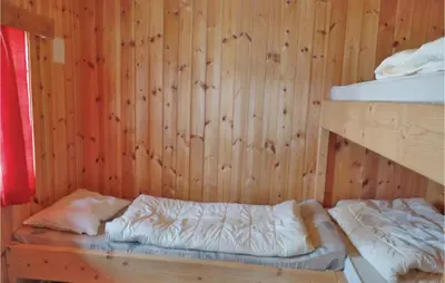 a room with a wooden wall with a bunk bed at Holiday Home Ringebu Måsåplassen Ii in Ringebu