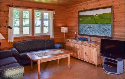 a living room with a tv and a couch and a table at Holiday Home Hunndal Skumlivegen