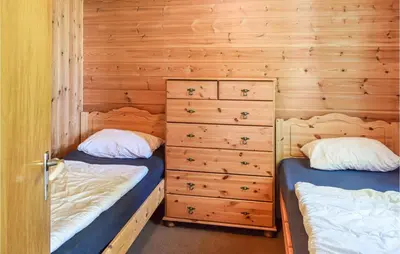 two beds in a room with wooden walls at Holiday Home Hunndal Skumlivegen