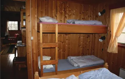 a room with two bunk beds in a wooden wall at Thorleifsbuskogheim in Vang I Valdres