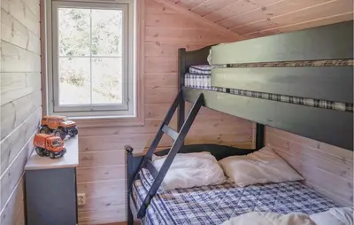 a bedroom with a bunk bed in a log cabin at Amazing Home In Hol With Sauna in Hol