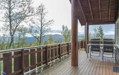 a wooden deck with a table and chairs on it at Amazing Home In Hol With Sauna in Hol