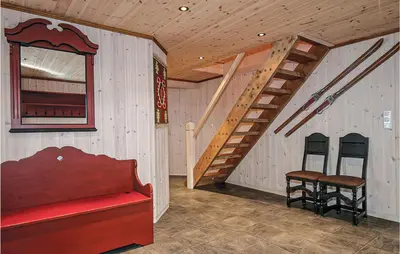 a room with a wooden staircase and two stools at Skarsnuten in Hemsedal