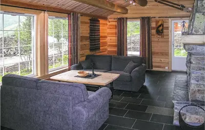 a living room with couches and a table in a room at Skarsnuten in Hemsedal