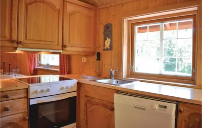 a kitchen with wooden cabinets and a sink and a stove at Holde in Hemsedal