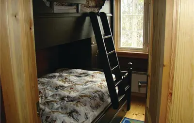 a bunk bed in a small room with a bed in it at Holiday Home Flå Øvre Reinsjøfjell in Flå