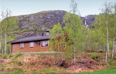 a house in the woods with a mountain in the background at Holiday Home Hemsedal Rusto Raunhaug in Hemsedal