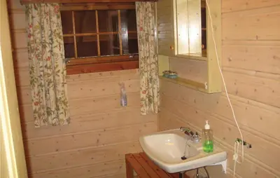 a bathroom with a sink in a wooden wall at Holiday Home Hemsedal Rusto Raunhaug in Hemsedal