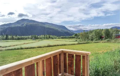 a wooden deck with a view of a field and mountains at Holiday Home Hemsedal Rusto Raunhaug in Hemsedal